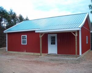 Red agricultural pole barn with white trim and porch